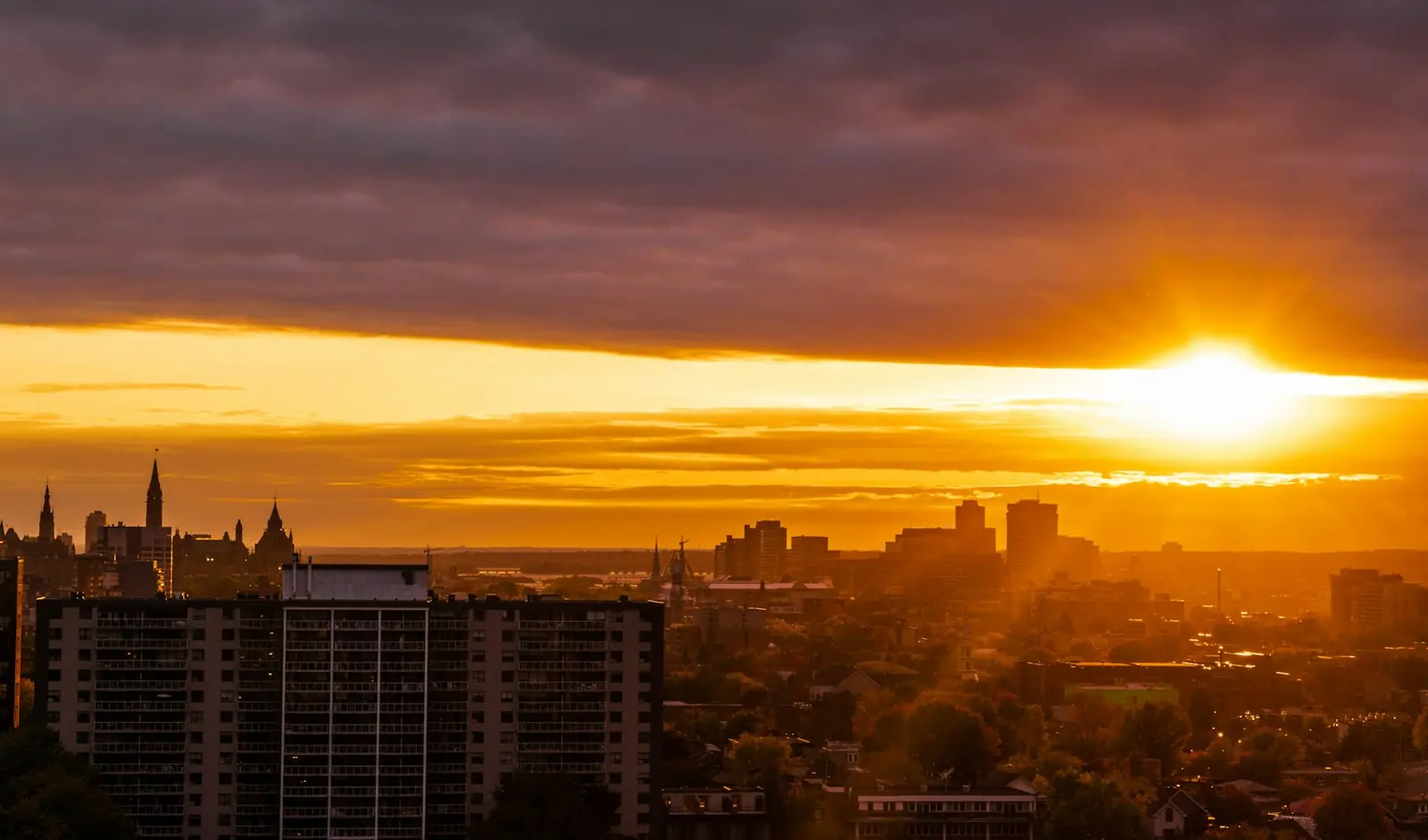 Downtown Ottawa skyline at sunset, Parliament spires against a golden sky