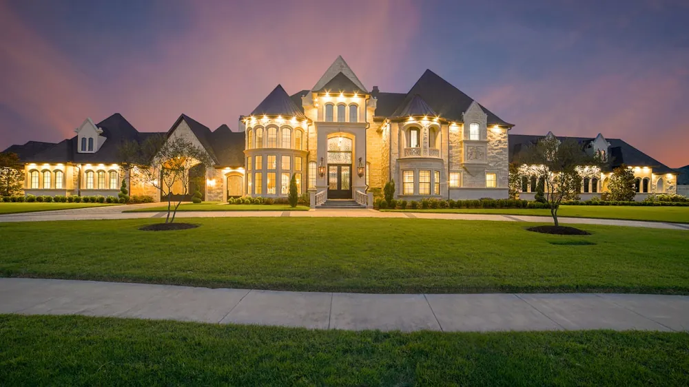 Grand estate at dusk, lit — illustrative